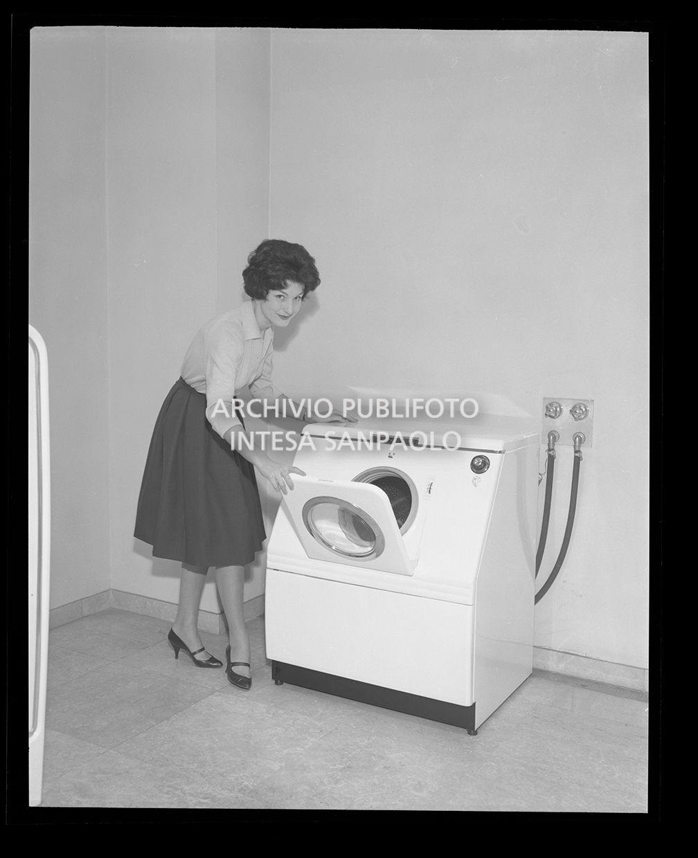 Donna mentre mostra la lavabiancheria automatica Fiat<br>25573
