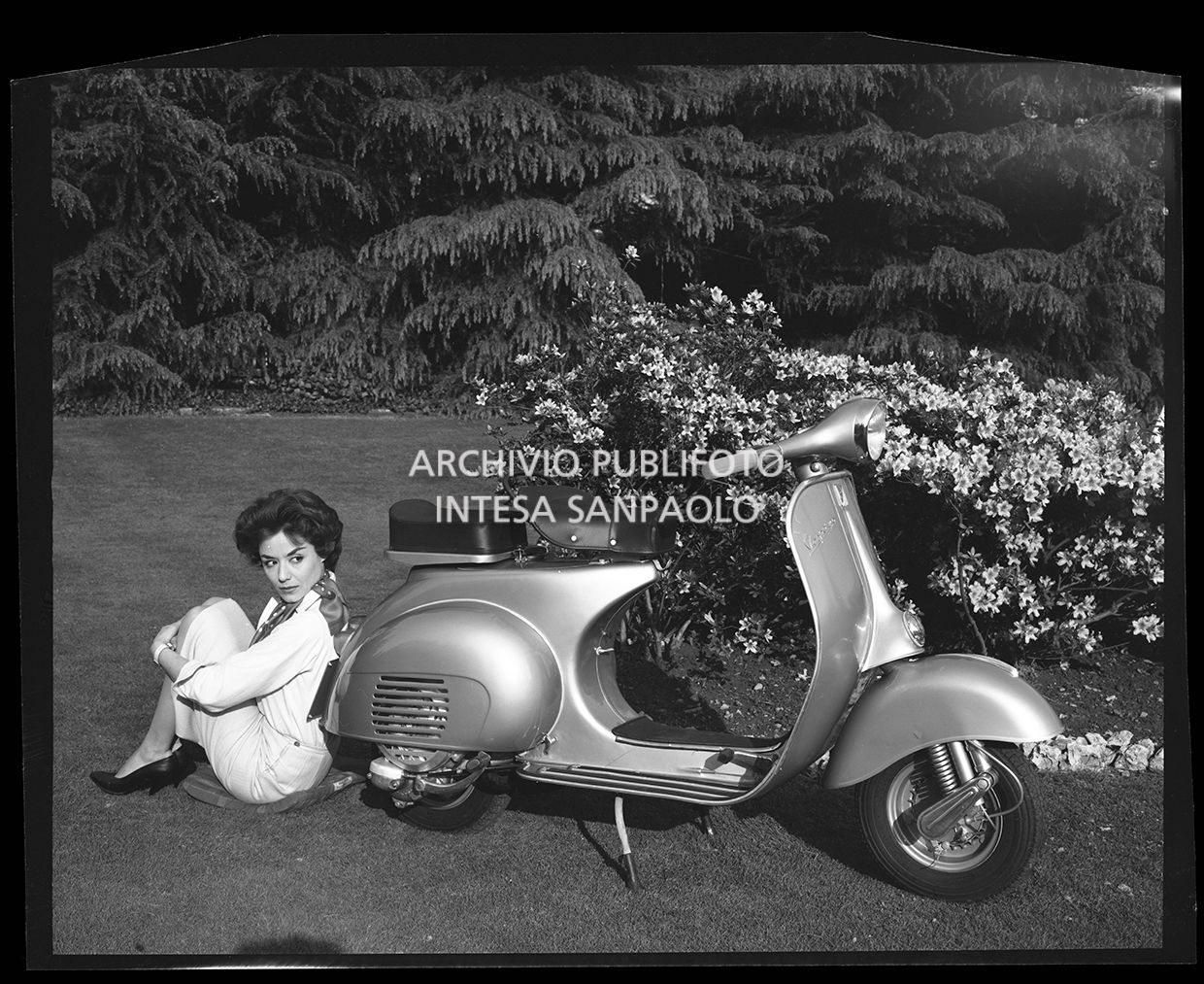 Vespa in un parco con accanto una donna seduta<br>27513