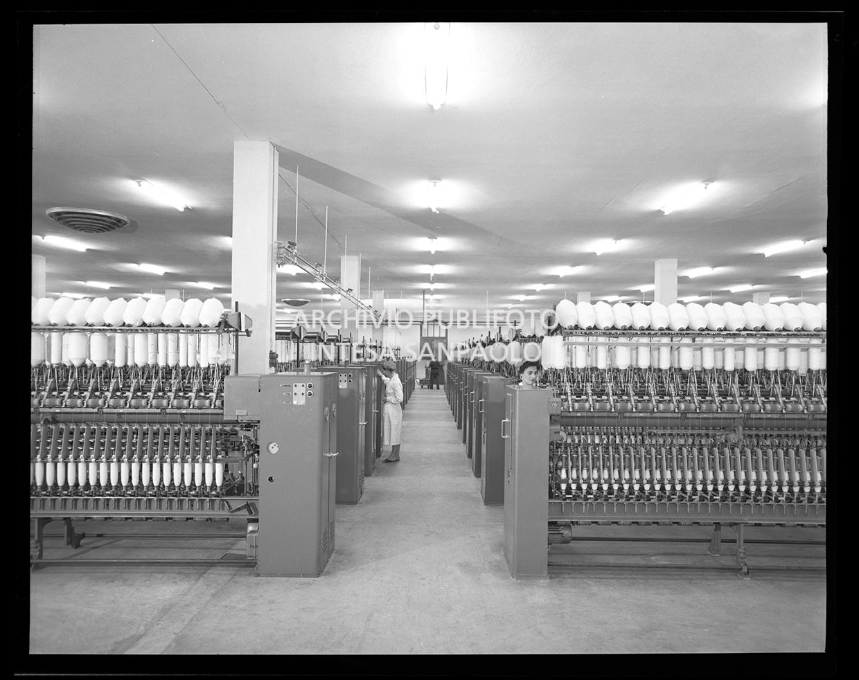 Macchinari con fusi, donne ed un uomo al lavoro<br>27594