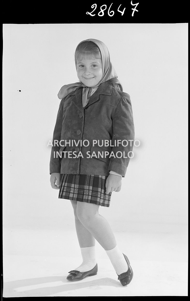 Bambina con giacca, gonna a quadri e foulard in testa<br>28647