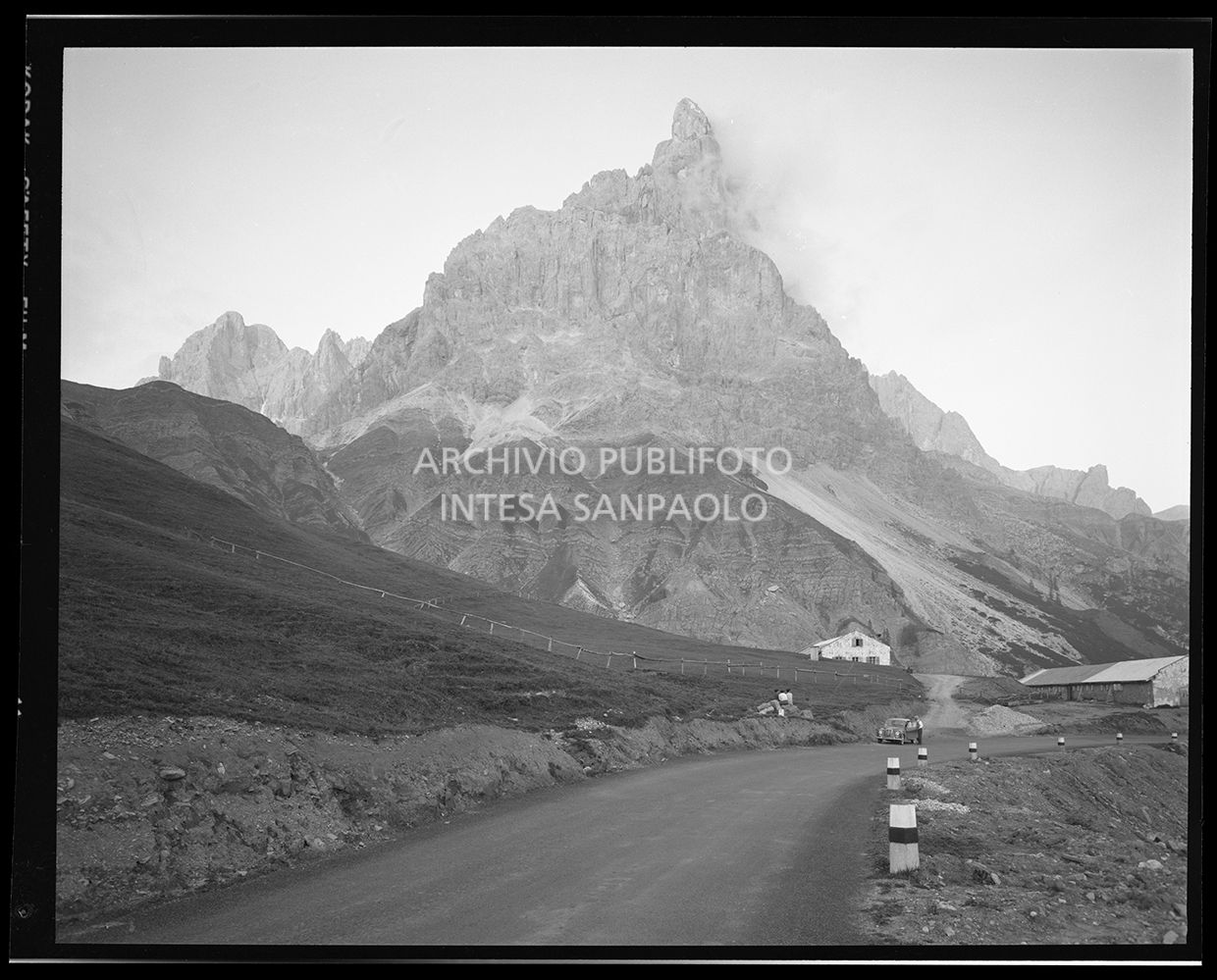 Strada di montagna. In lontananza un uomo sale sull'automobile<br>29904