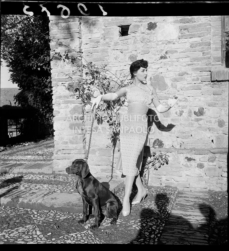 Stessa indossatrice ed abito degli scatti 10642, 10643 (senza soprabito) con cane al guinzaglio<br>10673