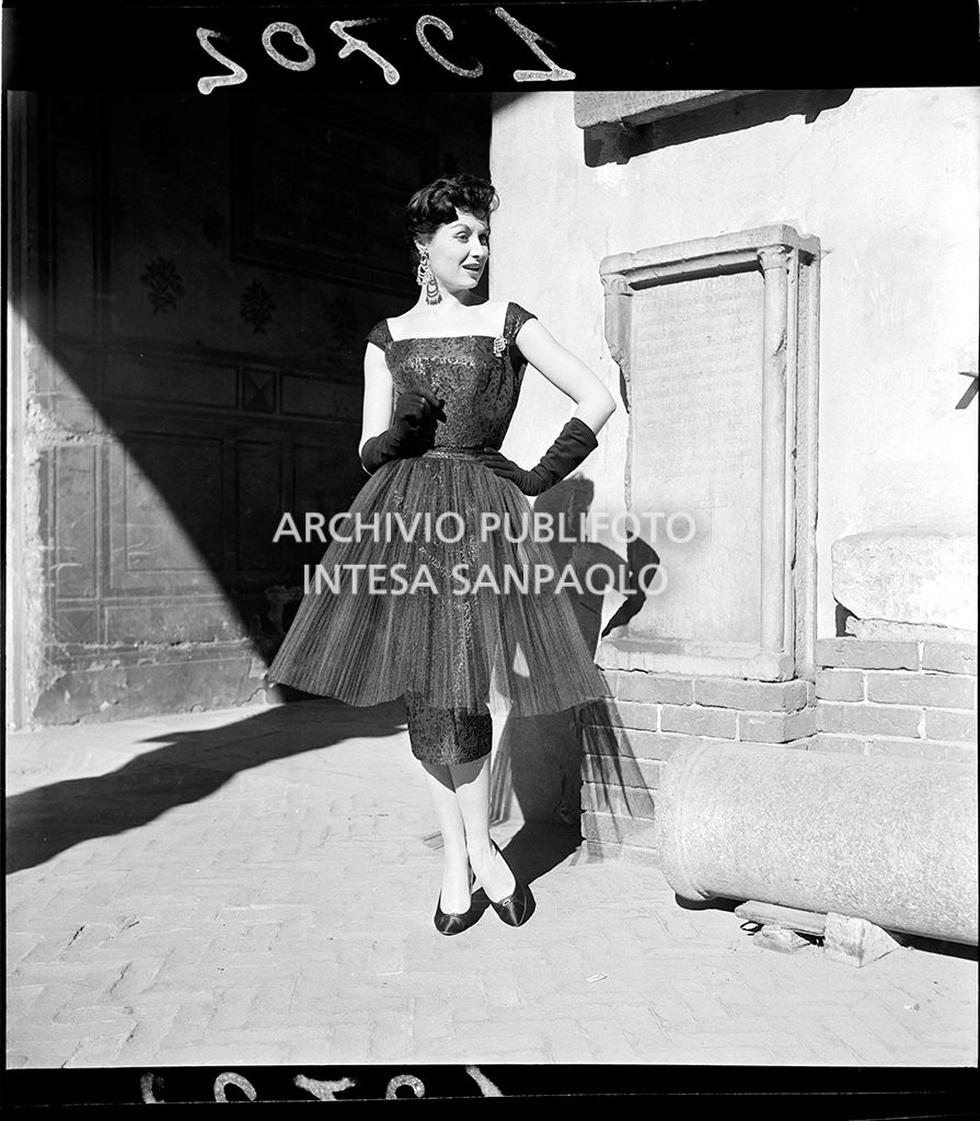 Indossatrice con abito con doppia gonna, una a tubino e una ampia e guanti al Castello Sforzesco<br>10702