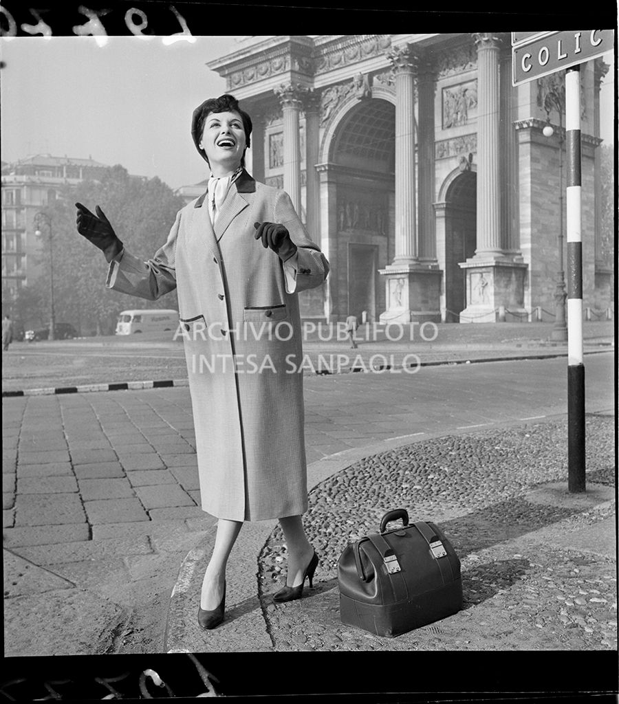 Indossatrice con soprabito, a righe, guanti, foulard e borsa davanti all'Arco della Pace<br>10776