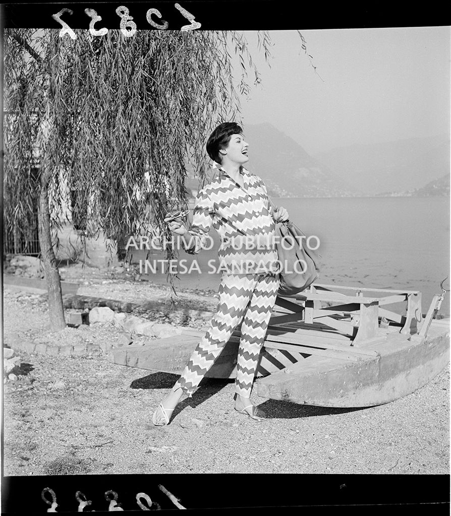 Indossatrice con camicia e pantaloni abbinati con fantasia a zig zag e borsa in riva al lago<br>10837