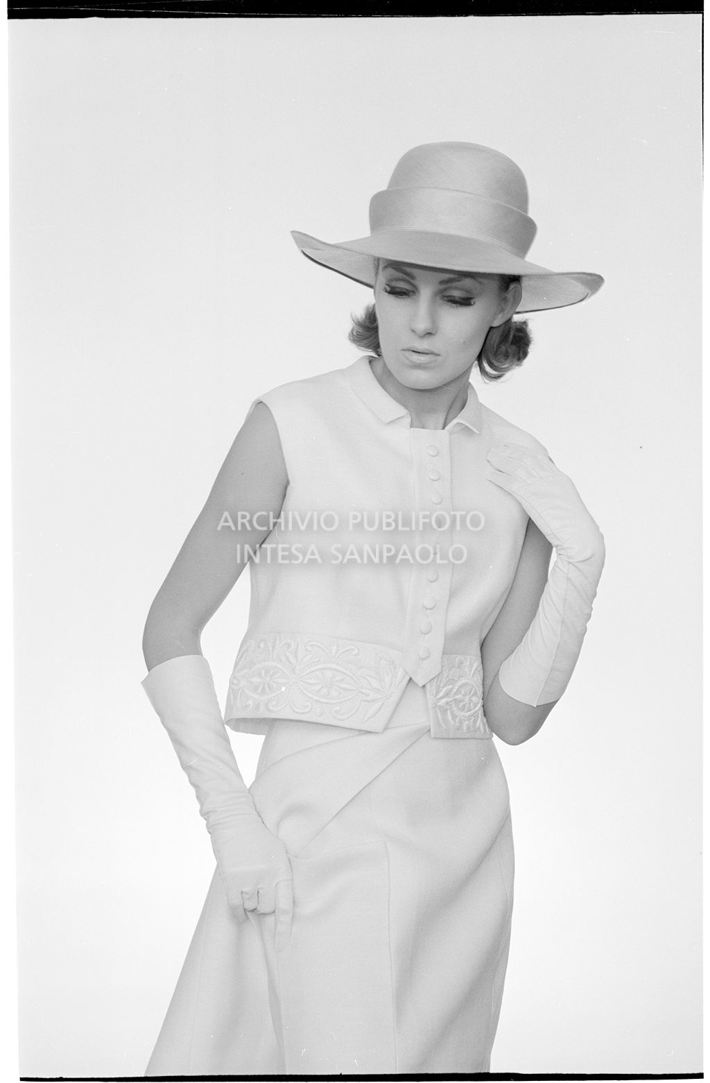 Indossatrice con tailleur senza maniche, guanti e cappello<br>10915