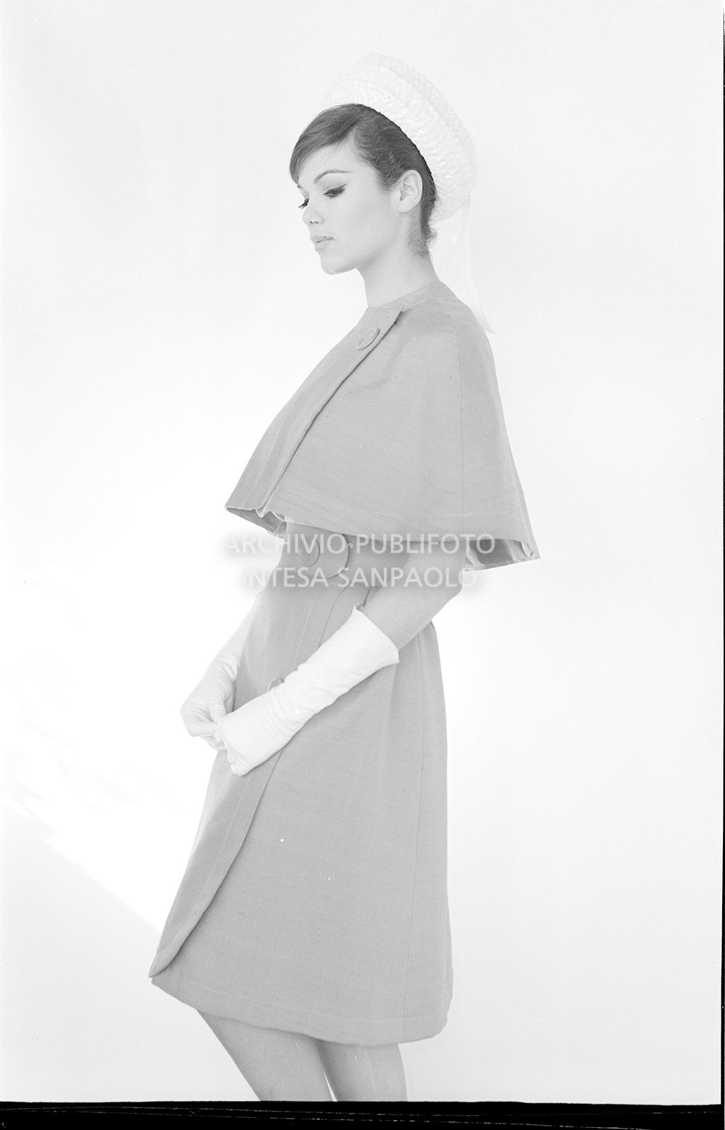 Indossatrice con mantella e gonna abbinata, guanti e cappello<br>10921