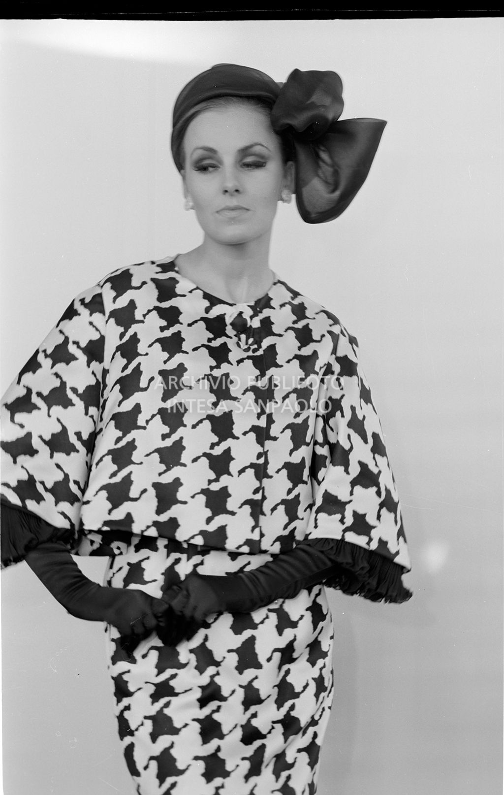 Indossatrice con tailleur pied de poule, foulard in testa e guanti<br>10934