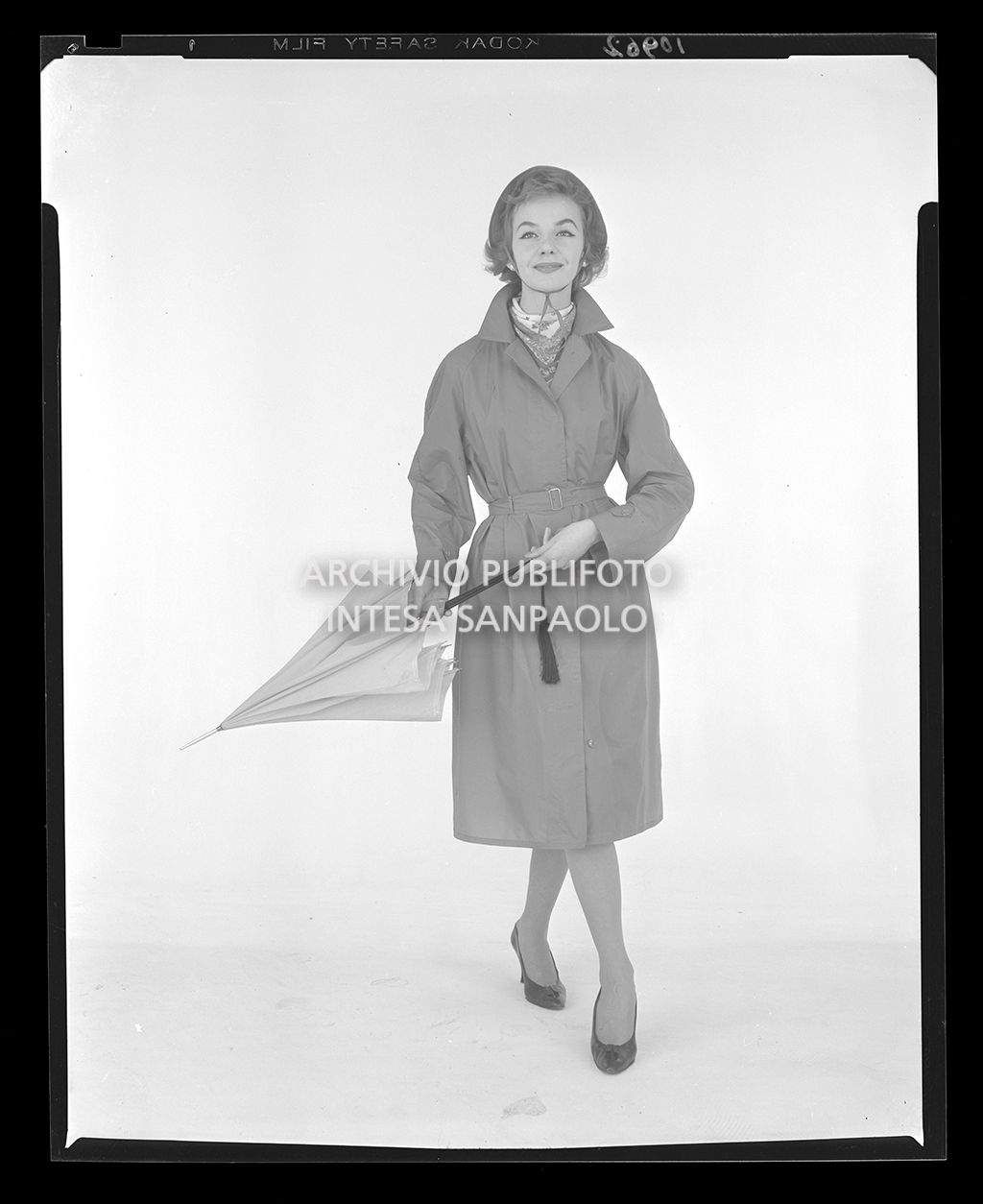 Indossatrice con impermeabile, cappello, foulard e ombrello<br>10962