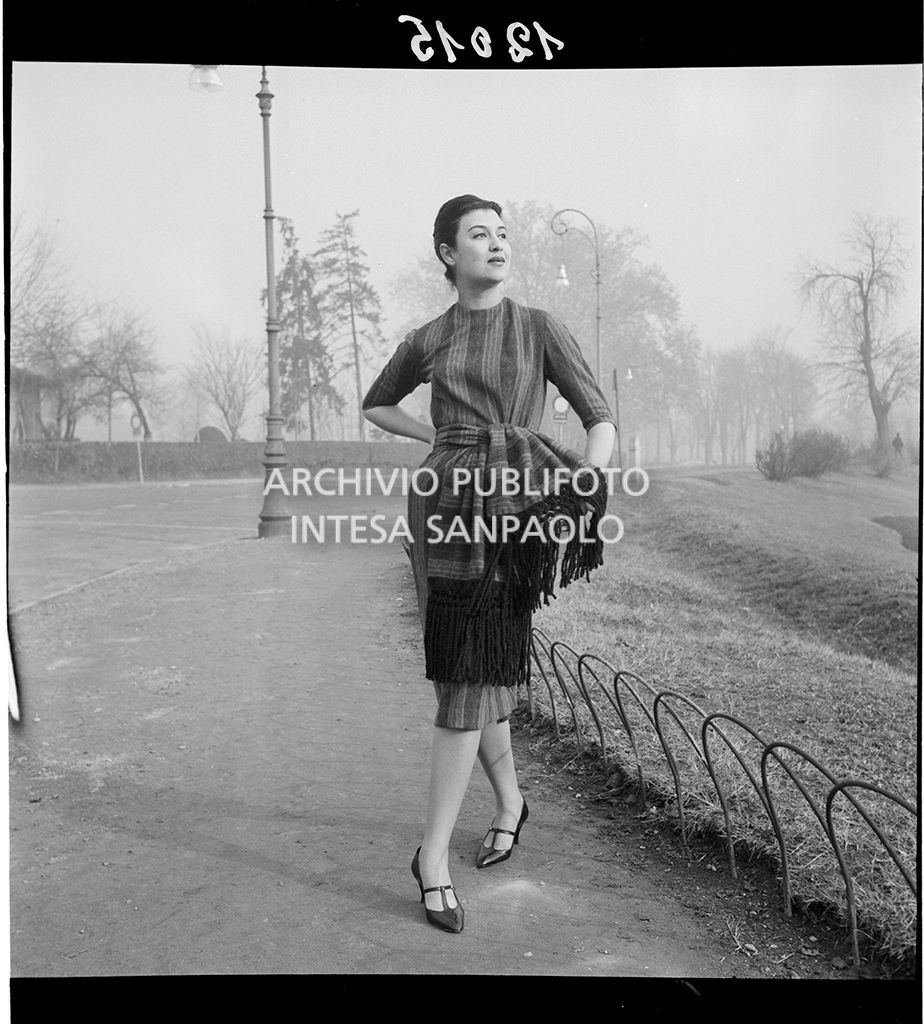 Indossatrice con abito a righe e sciarpa della stessa stoffa legata in vita<br>12015