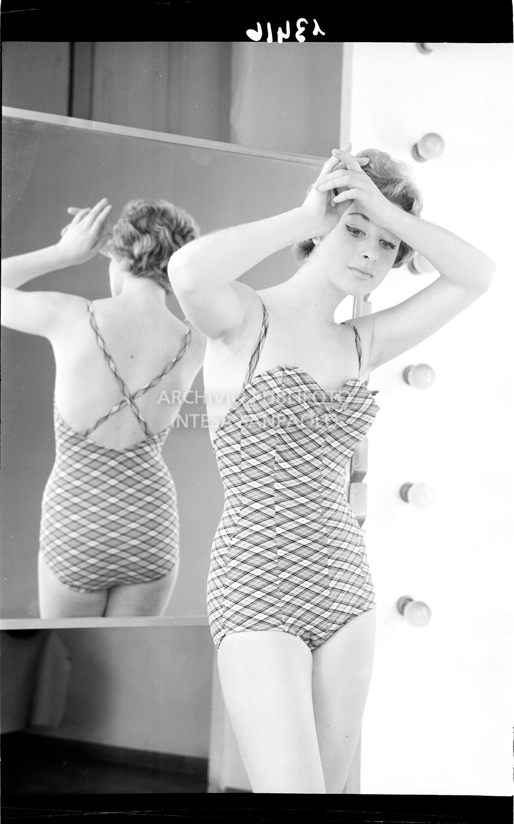 Indossatrice con costume intero allo specchio<br>13416