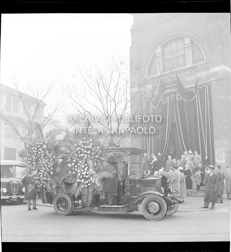 Carro funebre con corone sul sagrato di una chiesa<br>13902