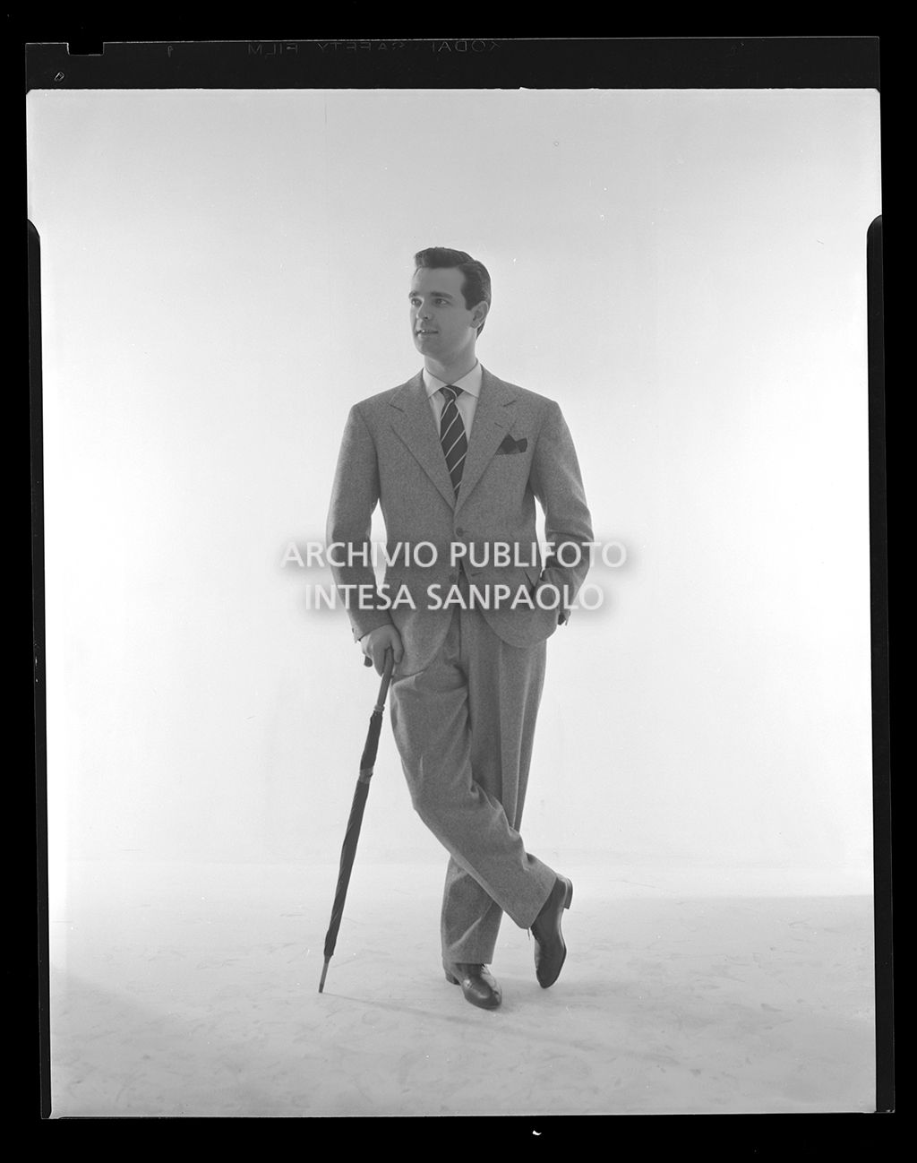 Uomo in abito elegante con pochette, cravatta e ombrello<br>14449