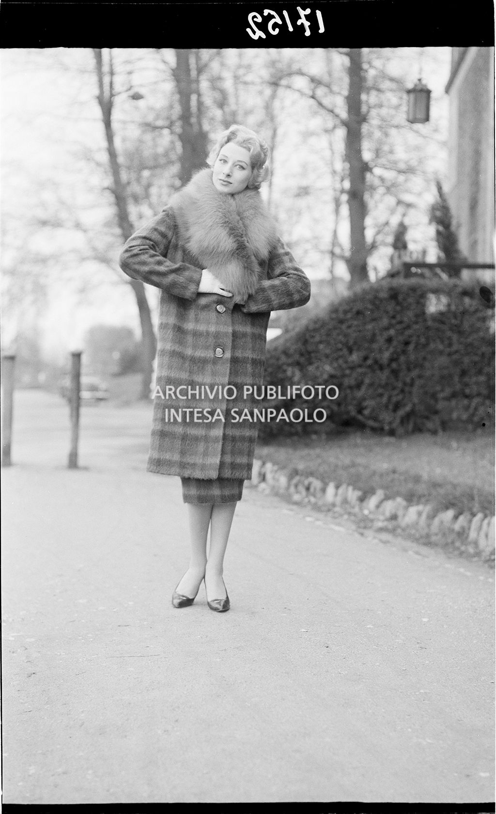 Indossatrice con cappotto e collo di pelliccia nel parco<br>17152