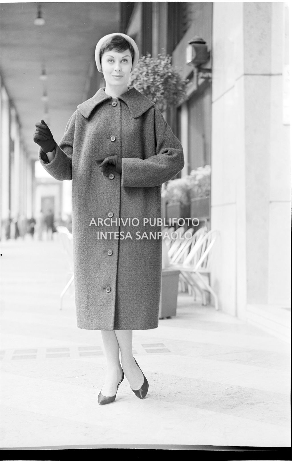 Indossatrice con cappotto, guanti, cappello e ombrello per strada<br>18547