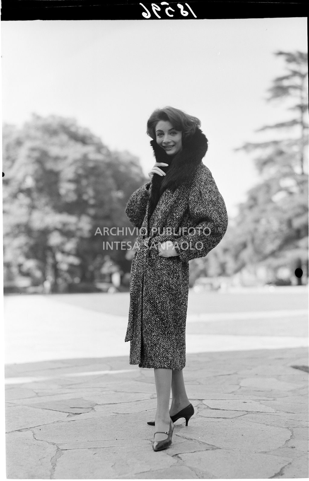 Indossatrice con cappotto con collo di pelliccia, in un parco<br>18596