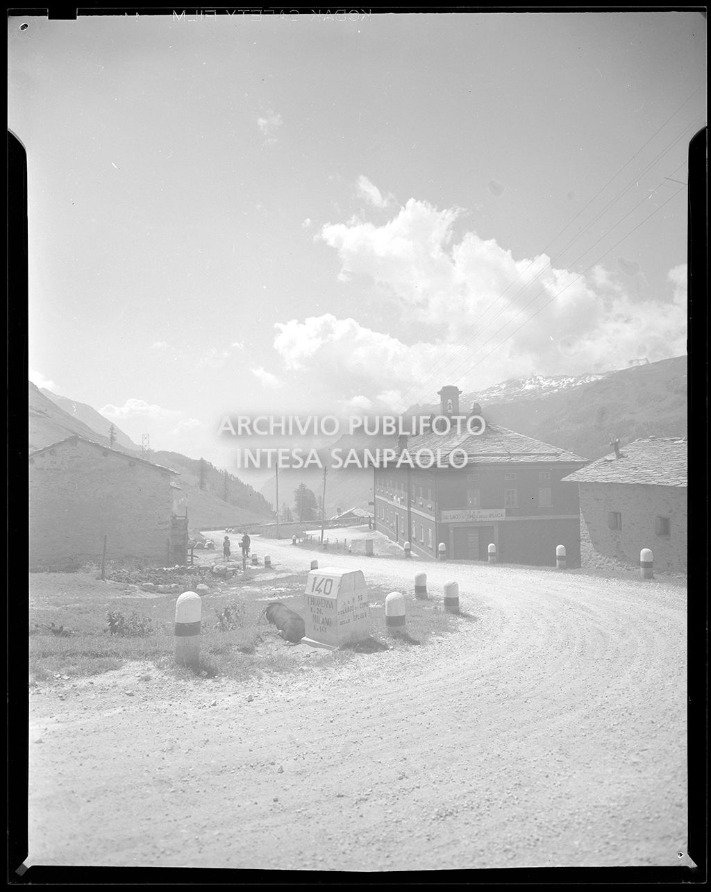 Strada in cui si vede una pietra miliare con la scritta: "140 Chiavenna Km 20, Milano Km 140. s.s. N. 36 del lago di Como e dello Spluga"<br>20149