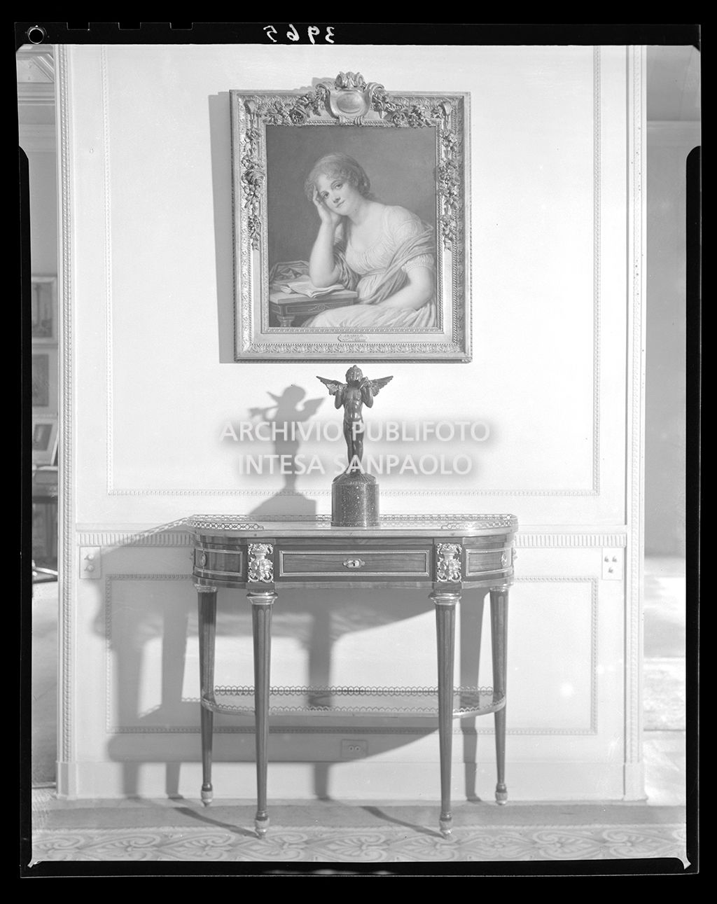 Tavolino con statua e dipinto di donna appeso alla parete<br>3965