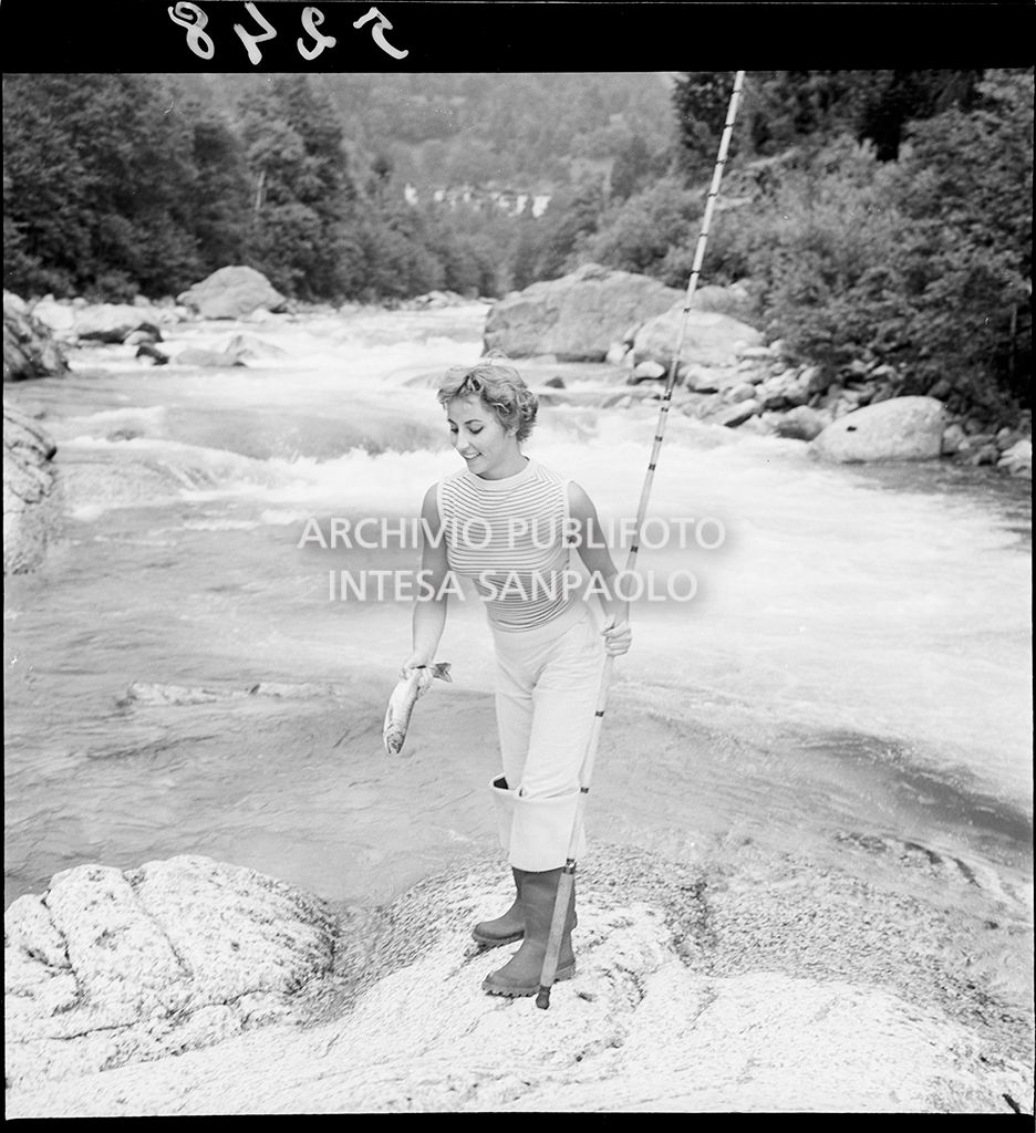 Donna con canna da pesca e pesce in mano<br>5248