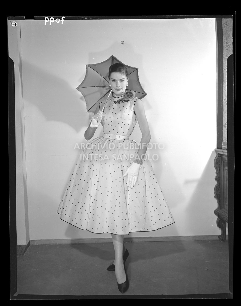 Donna con abito al polpaccio ampio e a pois con guanti e ombrello da sole<br>7099