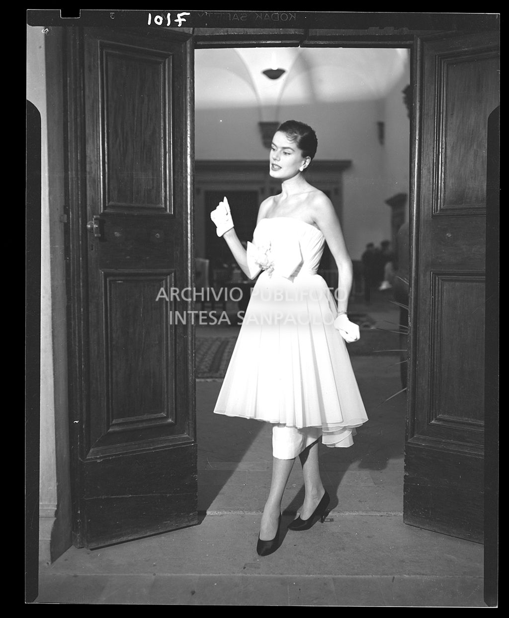 Donna con abito senza spalline al polpaccio con un grande fiocco in vita e guanti<br>7101