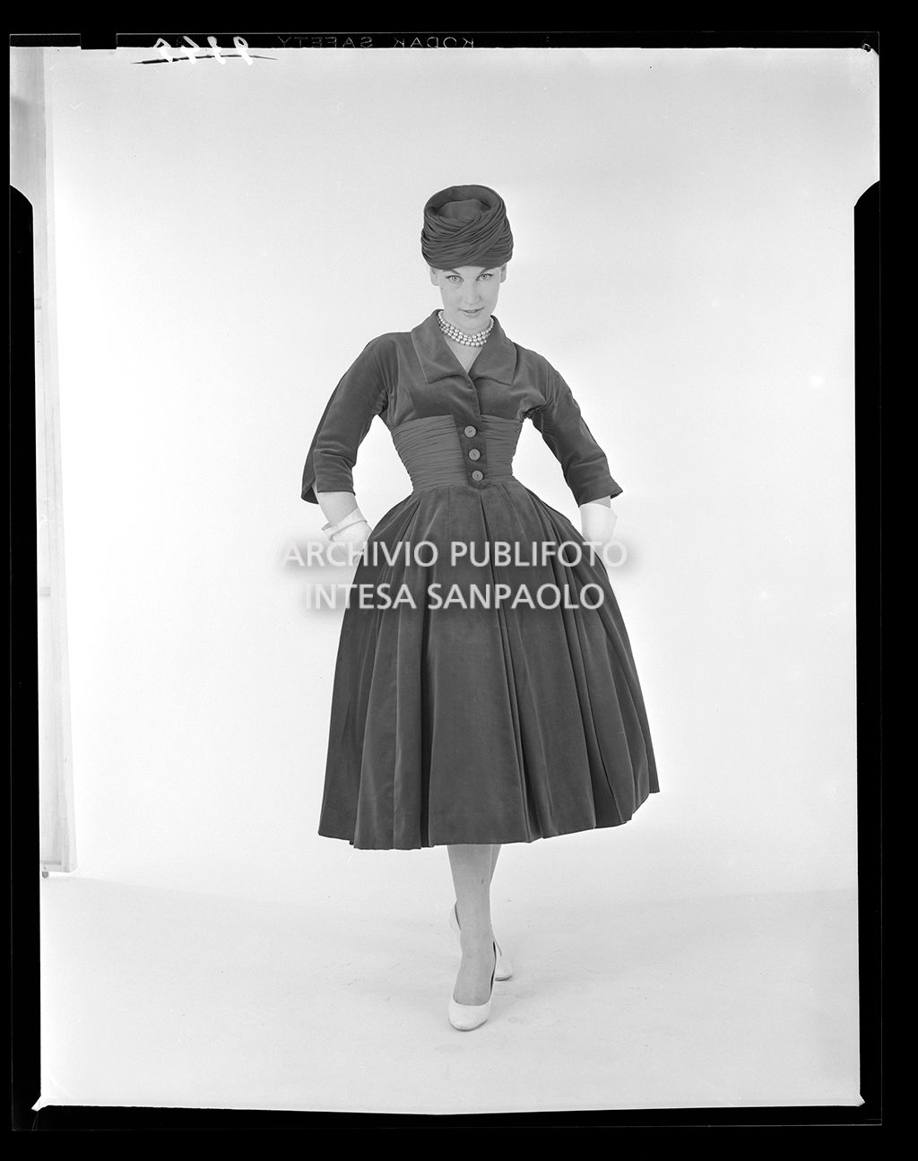 Indossatrice con abito con gonna ampia al polpaccio, cappello e guanti<br>9345