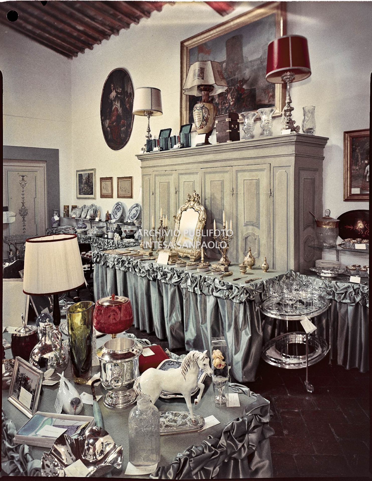 Sala in cui sono esposti i regali ricevuti in occasione delle nozze di Umberto Agnelli e Antonella Bechi Piaggio. Sono visibili: un set per la toletta, servizi di bicchieri e porcellane, lampade, vasi ed oggetti vari<br>2255