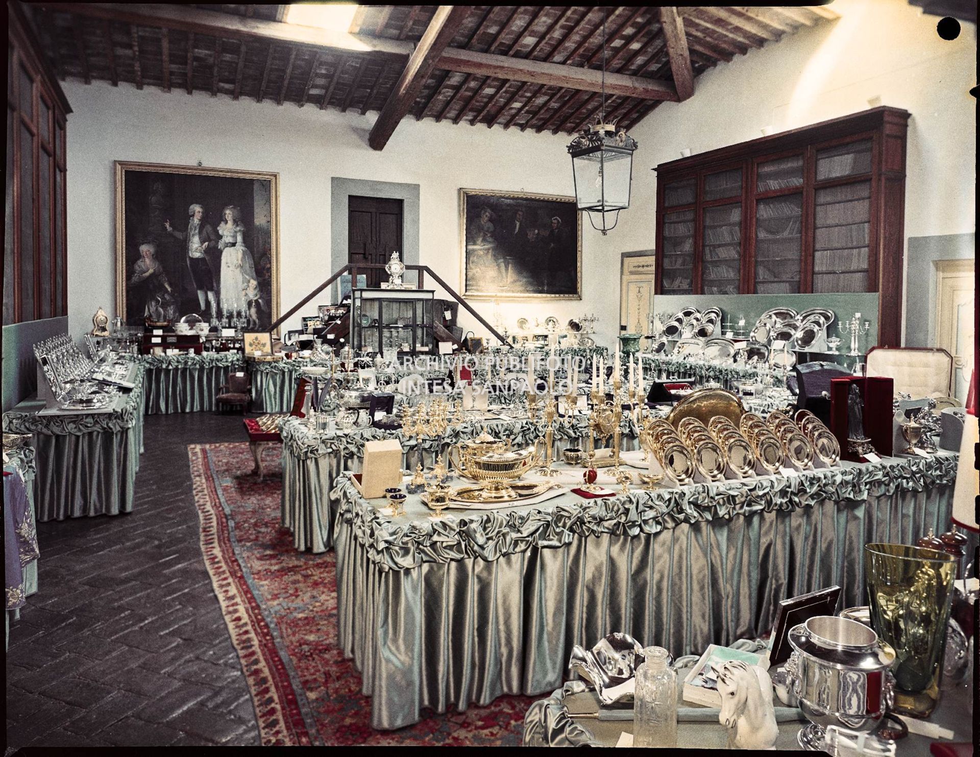 Sala in cui sono esposti i regali ricevuti in occasione delle nozze di Umberto Agnelli e Antonella Bechi Piaggio. Sono visibili: candelabri e servizi di piatti in oro e argento ed altri oggetti vari<br>2256