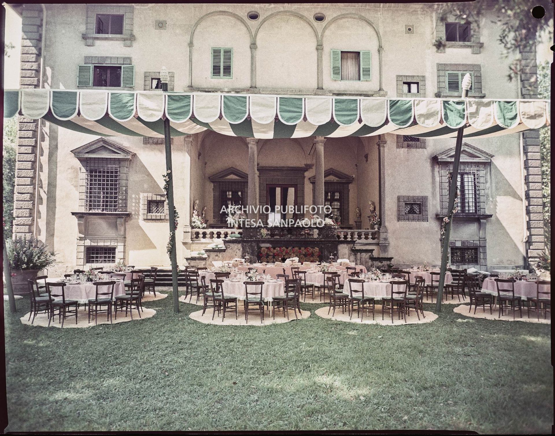 Allestimento per il ricevimento del matrimonio tra Umberto Agnelli e Antonella Bechi Piaggio con tavoli e sedie sotto ad un tendone nel giardino della villa<br>2260
