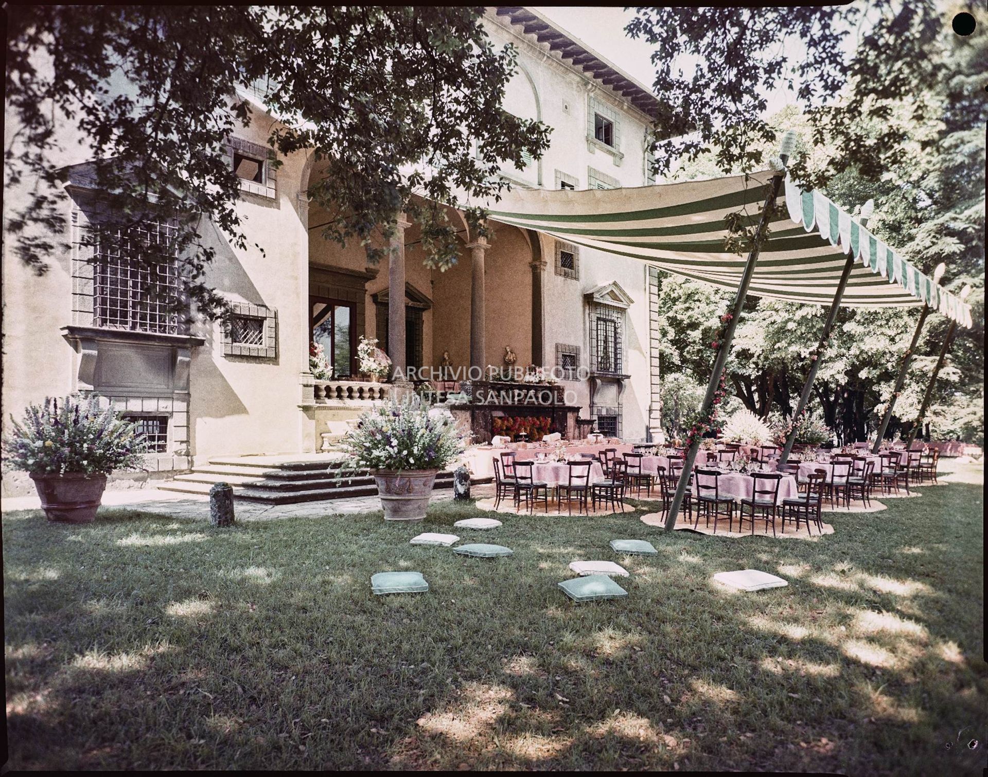 Allestimento per il ricevimento del matrimonio tra Umberto Agnelli e Antonella Bechi Piaggio con tavoli e sedie sotto ad un tendone nel giardino della villa<br>2262
