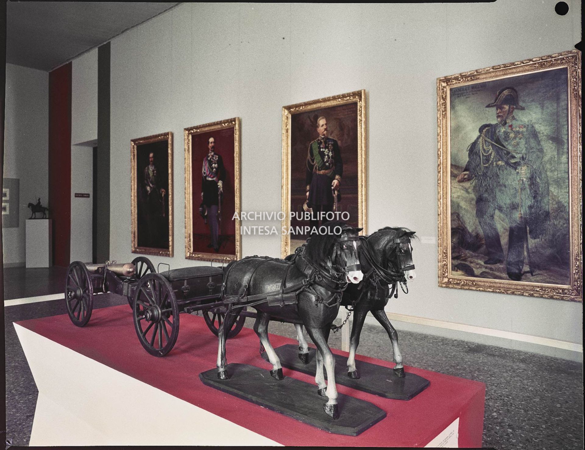 Sala espositiva delle mostra "Il Cinquantanove" a Palazzo Reale di Milano con modellino due un carro con cannone trainato da due cavalli e ritratti sulla parete<br>2320