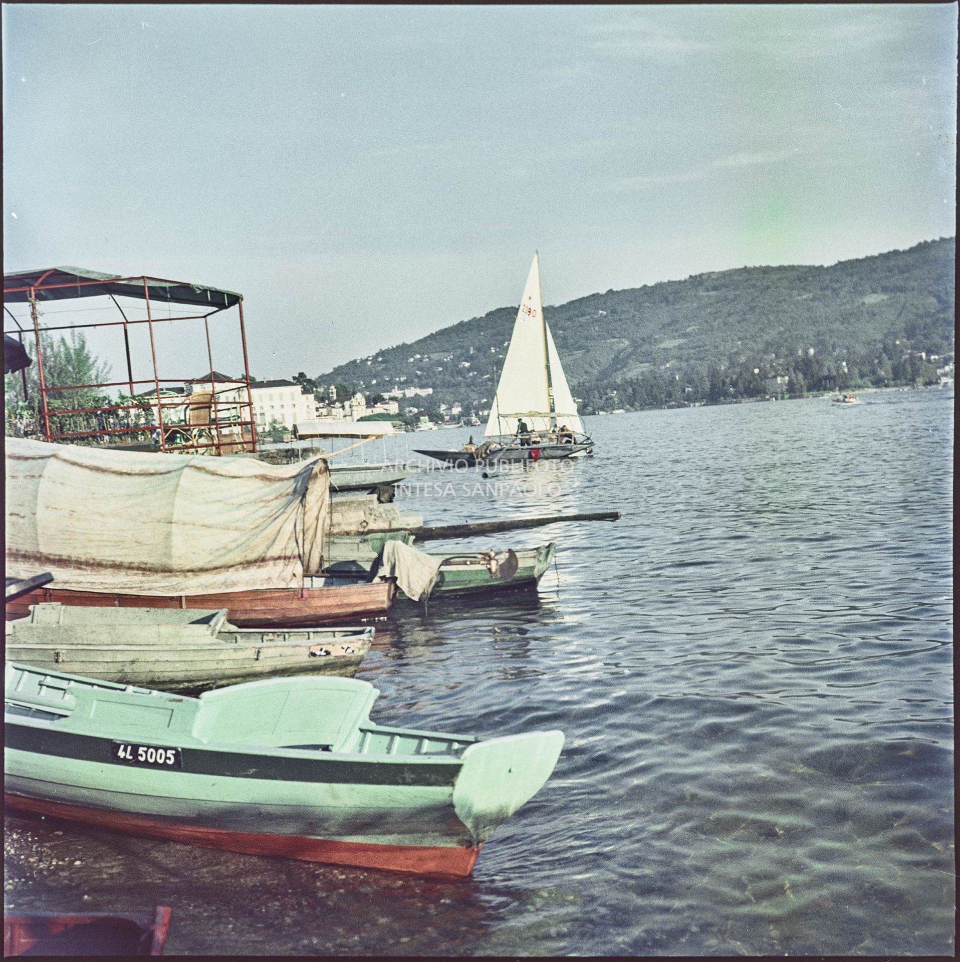 Vista di imbarcazioni e di una piattaforma con tavolini sulla riva dell'Isola dei Pescatori sul lago Maggiore<br>332
