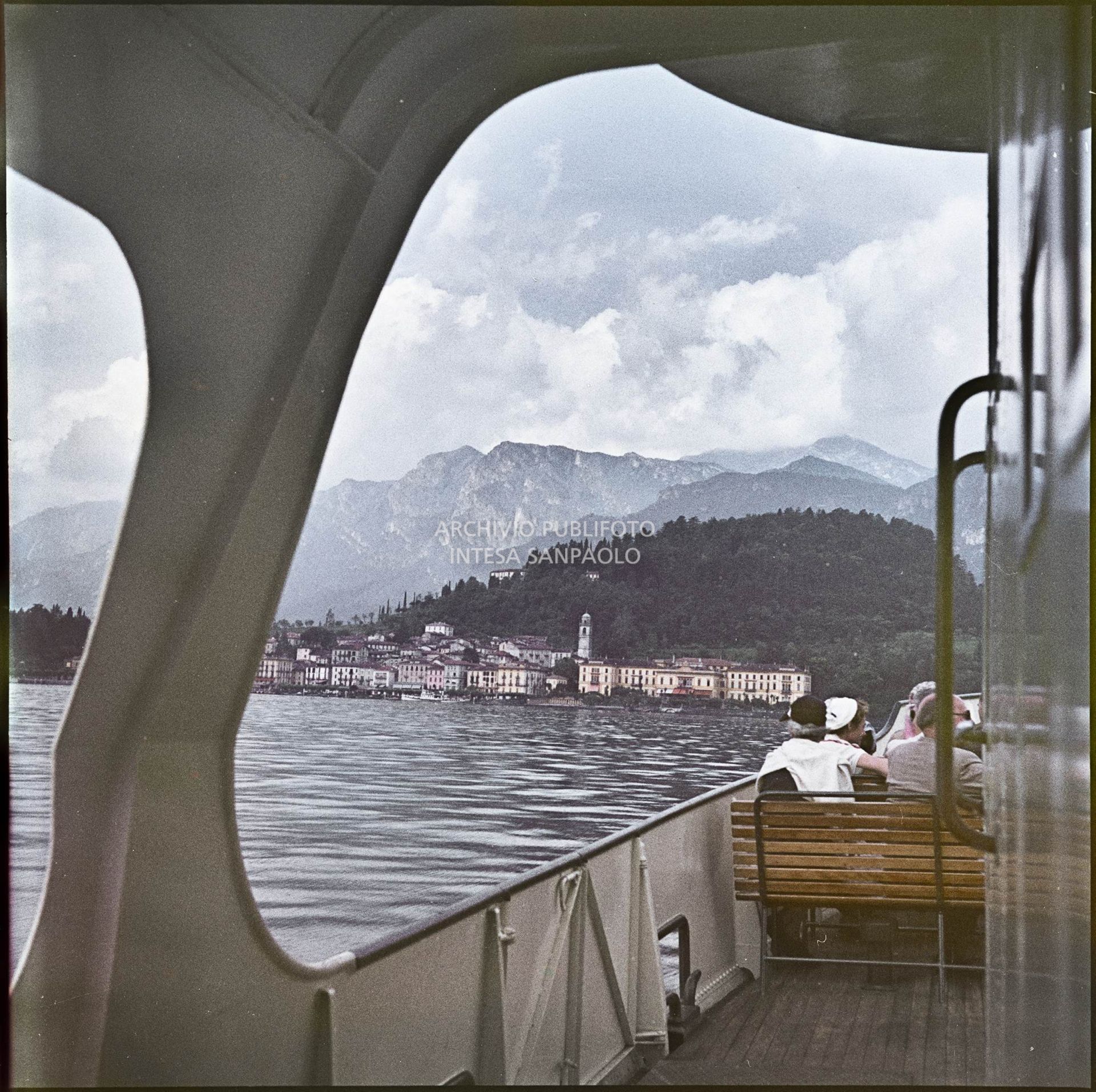 Montagne e lago visti da un traghetto con passeggeri a bordo<br>341