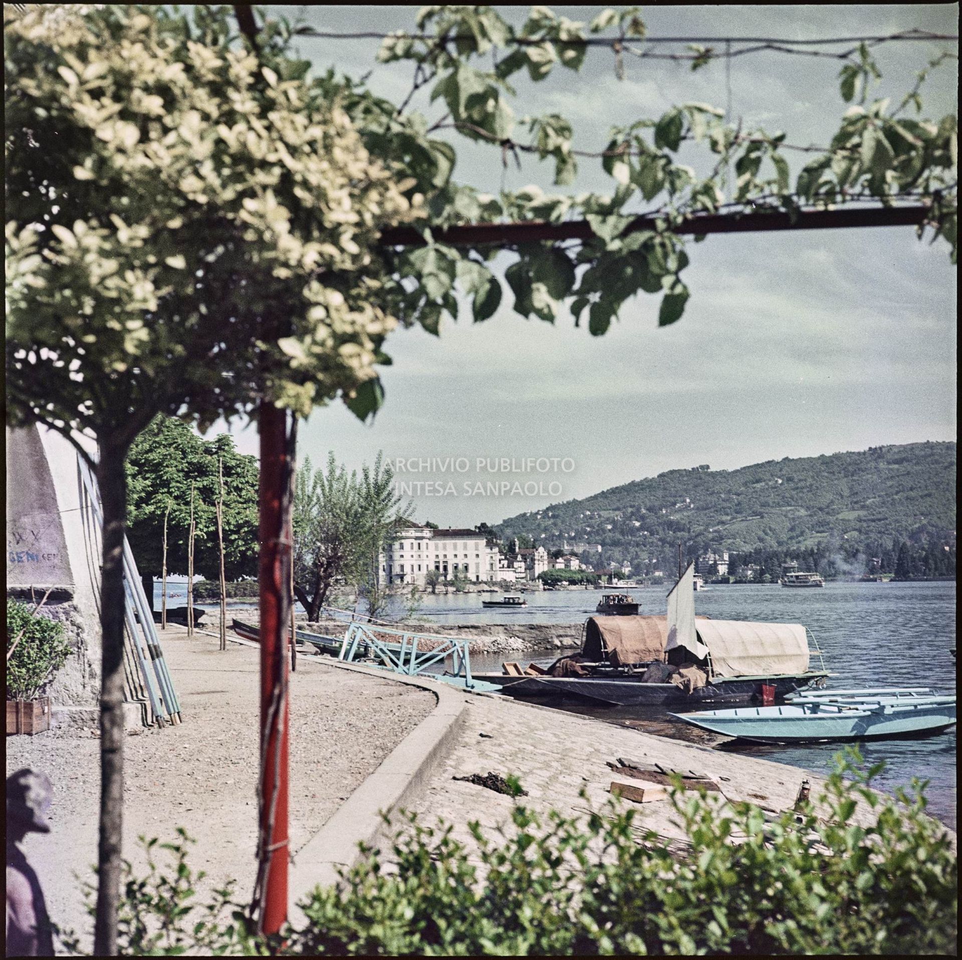 Vista del lungolago e dell'Isola dei Pescatori con barche attraccate alla riva<br>346