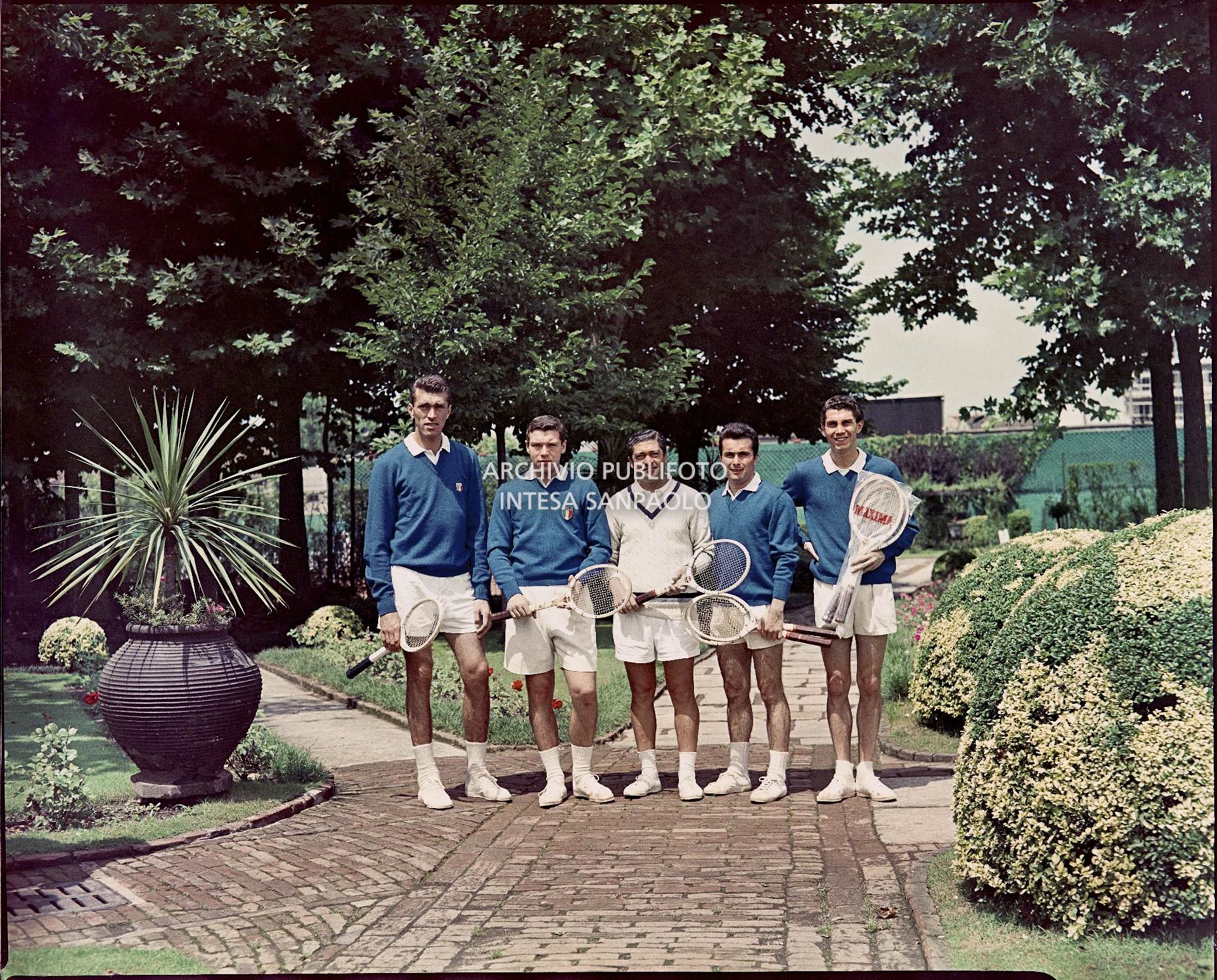 La squadra in posa con le racchette in un giardino<br>561