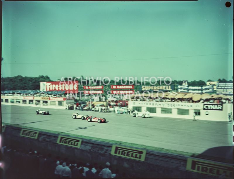 Vista dagli spalti della pista e delle automobili. Sono visibili le seguenti insegne pubblicitarie: Firestone, Castrol, Supershell, Motta, Cynar, Pirelli<br>1540