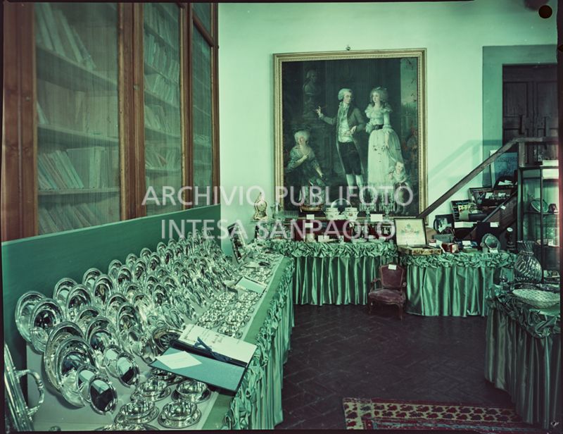 Sala in cui sono esposti i regali ricevuti in occasione delle nozze di Umberto Agnelli e Antonella Bechi Piaggio. Sulla desta un servizio di piatti in argento, sulla parete di fondo un quadro del Settecento<br>2259