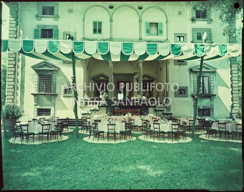 Allestimento per il ricevimento del matrimonio tra Umberto Agnelli e Antonella Bechi Piaggio con tavoli e sedie sotto ad un tendone nel giardino della villa<br>2260