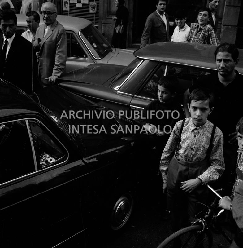 Folla di gente in via Bertani a Milano dove una Fiat 850 e una Fiat 1500 si sono scontrate per evitare l'automobile della banda Cavallero in fuga dopo la rapina all'agenzia del Banco di Napoli di largo Zandonai