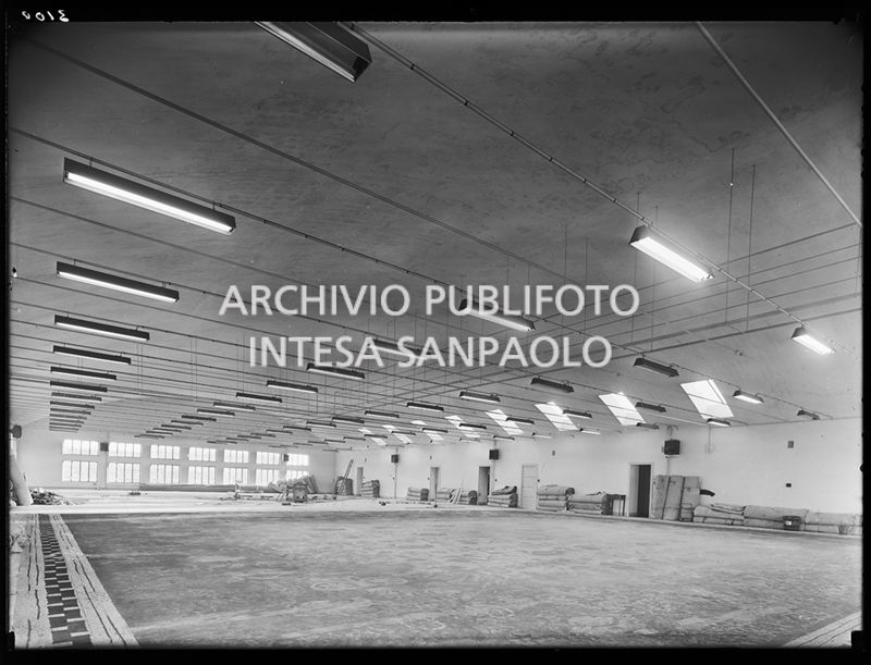 Veduta di un laboratorio della sezione scenografia del Teatro alla Scala di Milano. Addossati ai muri materiali di lavoro, per terra un fondale in lavorazione<br>716647/1