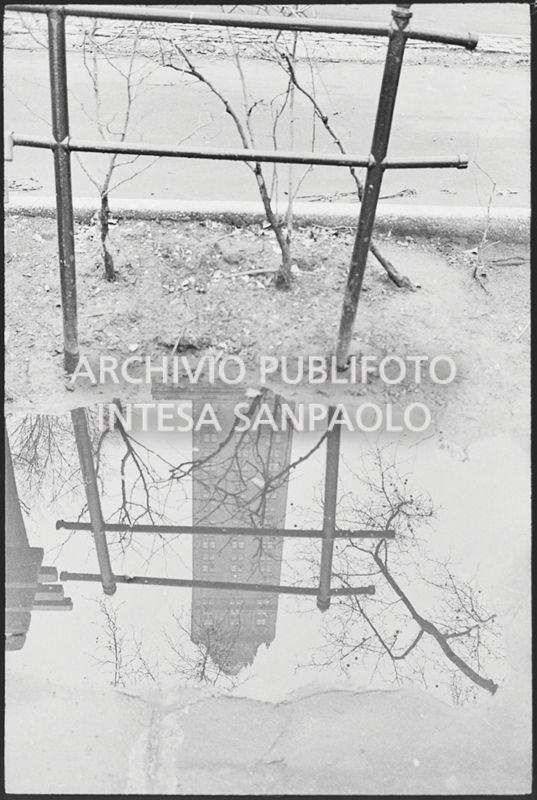 Riflesso di un grattacielo di New York in una pozzanghera il giorno della marcia contro la guerra in Vietnam promossa dallo Spring Mobilization Committee