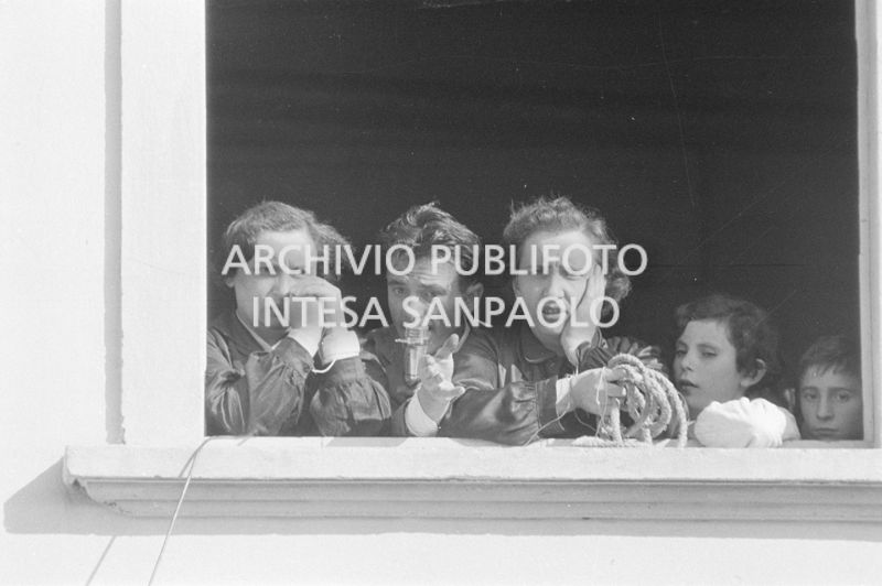 Due maestre della scuola elementare di Terrazzano, frazione di Rho in provincia di Milano, affacciate alla finestra a fianco a Arturo Santato, al microfono, che, con il fratello Egidio, le tiene in ostaggio con gli alunni e un'altra maestra