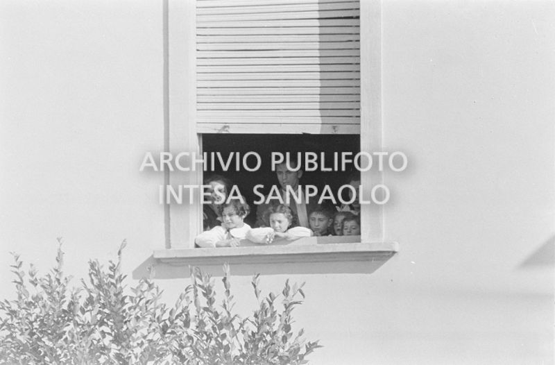 Alcuni alunni e due maestre, a una finestra della scuola elementare di Terrazzano, frazione di Rho in provincia di Milano, a fianco ad Arturo Santato, che, insieme al fratello Egidio, tiene in ostaggio gli alunni e le maestre