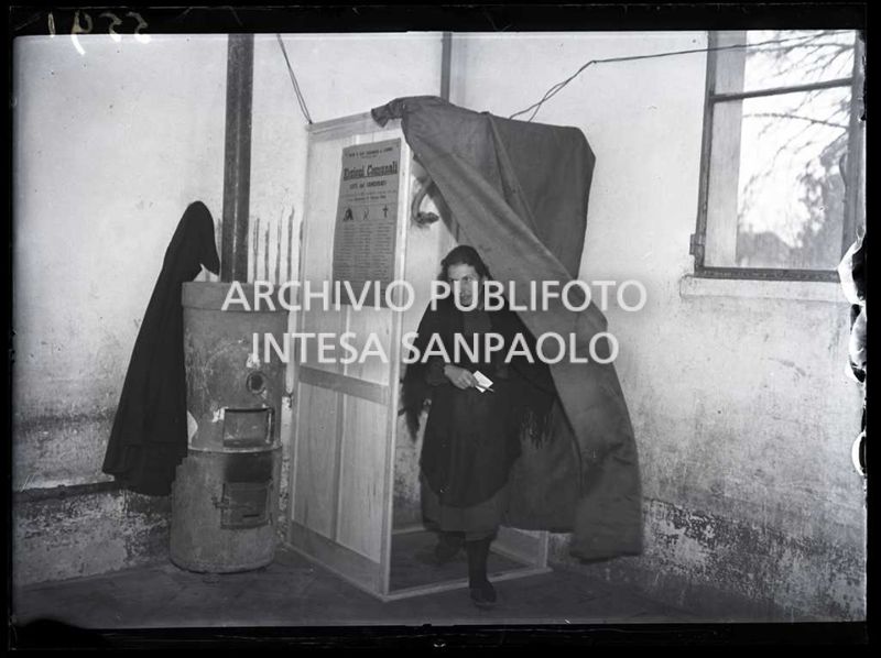 Una donna esce dalla cabina dopo aver votato alle elezioni comunali a San Colombano al Lambro, le prime elezioni con suffragio universale in Italia