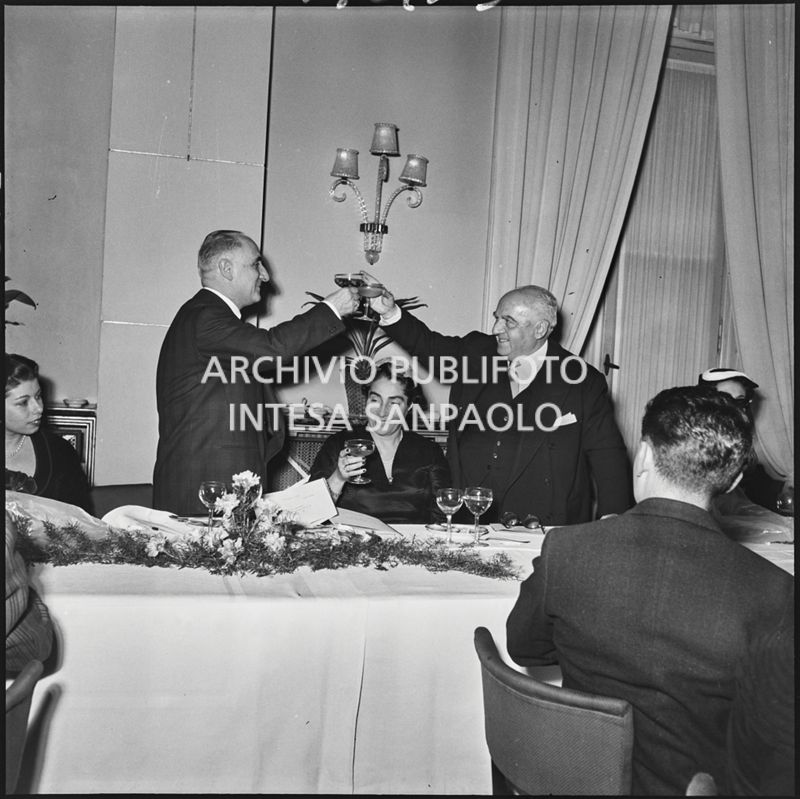 Due uomini brindano in occasione del banchetto della SAER al ristorante Tantalo di Milano<br>196133