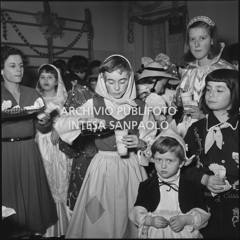 Bambine in maschera bevono Coca-Cola durante una festa di carnevale<br>201361