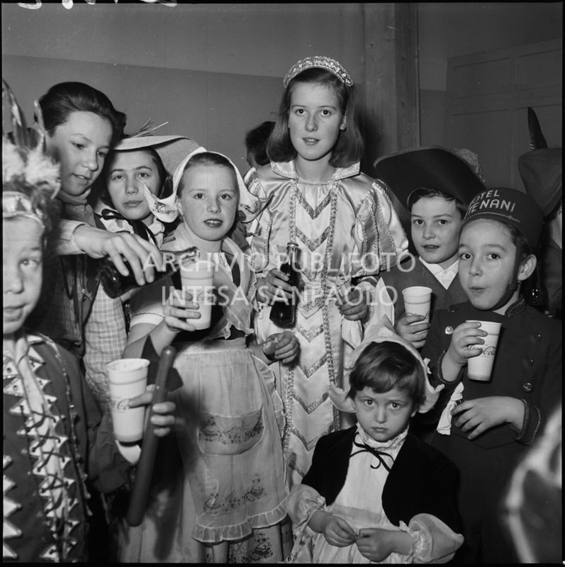 Bambine in maschera bevono Coca-Cola durante una festa di carnevale<br>201362