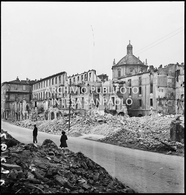 Edifici in via Molino delle Armi a Milano distrutti dai bombardamenti. Le macerie sono state addossate ai lati della strada per consentire la circolazione nella via. Sulla destra la basilica di San Lorenzo