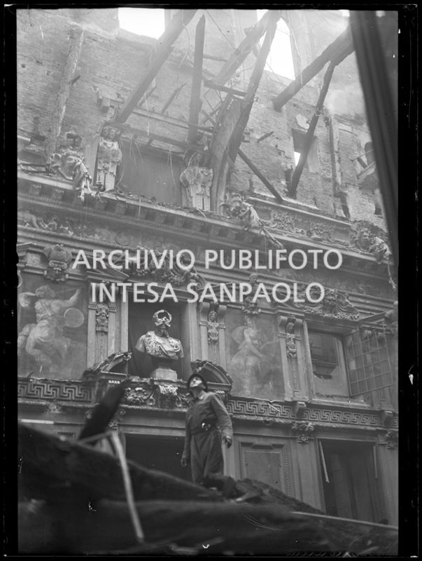 Un vigile del fuoco osserva i gravissimi danni al salone dell'Alessi di Palazzo Marino a Milano, causati dall'incendio divampato in seguito ai bombardamenti sulla città