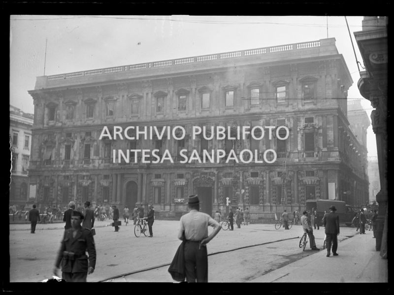 Palazzo Marino a Milano completamente bruciato e ancora fumante a causa dei bombardamenti durante l'intervento dei vigili del fuoco